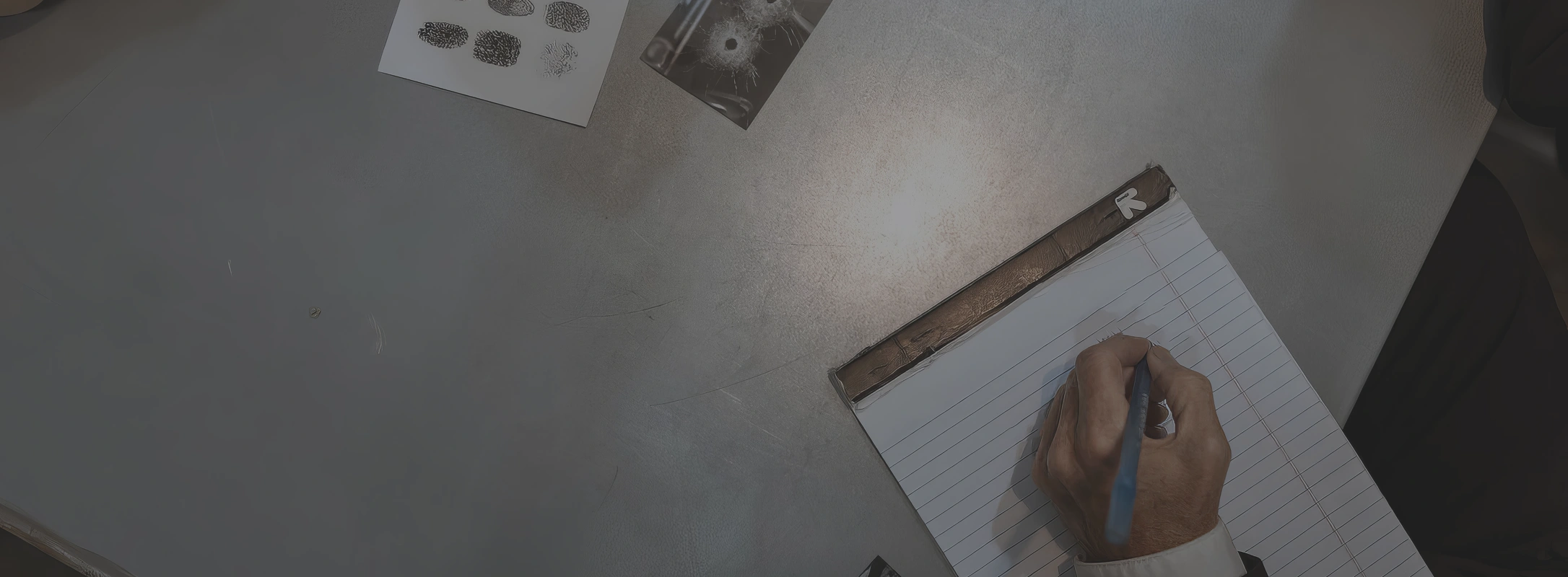 Private Investigator, GPS Tracking | Detective taking notes on a notepad while analysing fingerprint samples and crime scene photos.